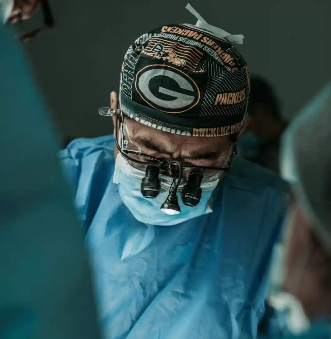 Surgeon wearing loupes during medical procedure.