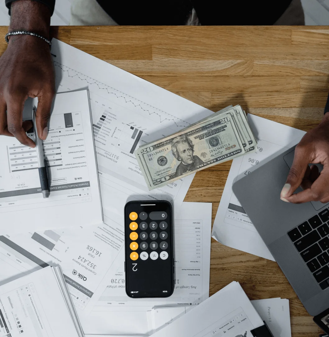 Calculating budget with cash on desk.
