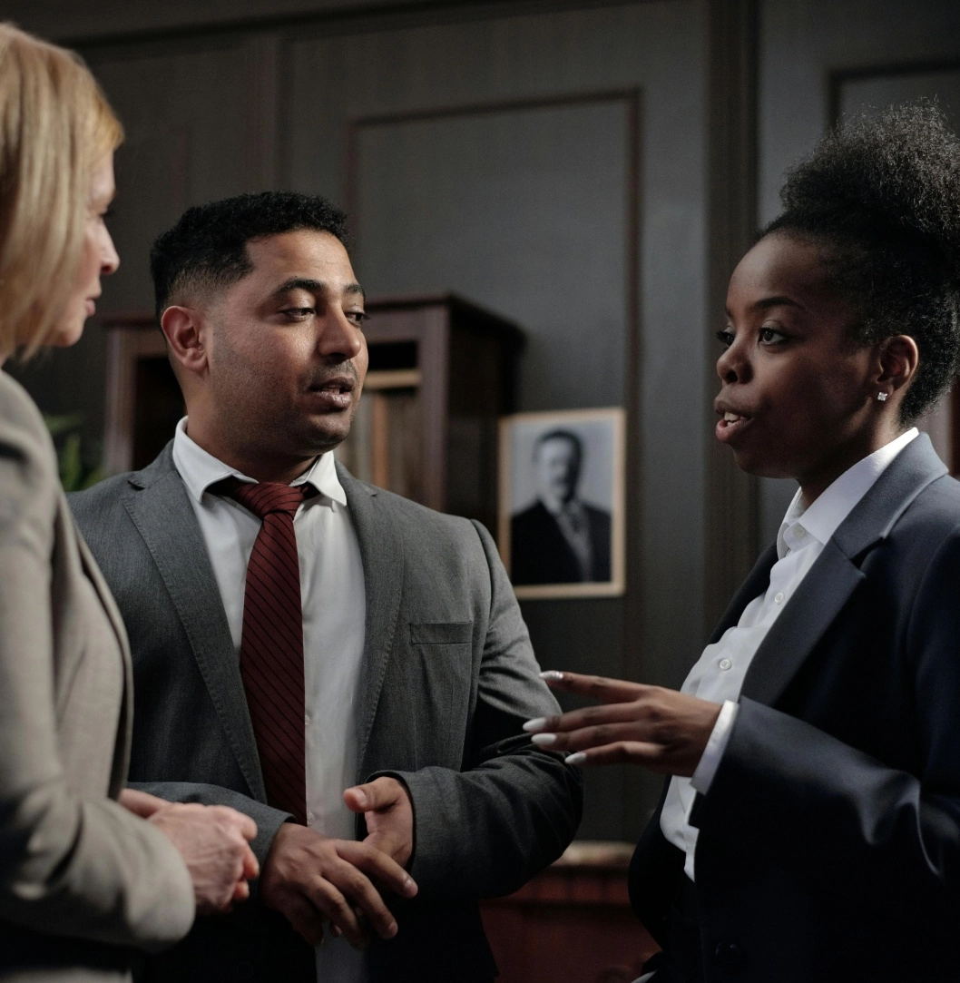 Three professionals discussing in an office setting.
