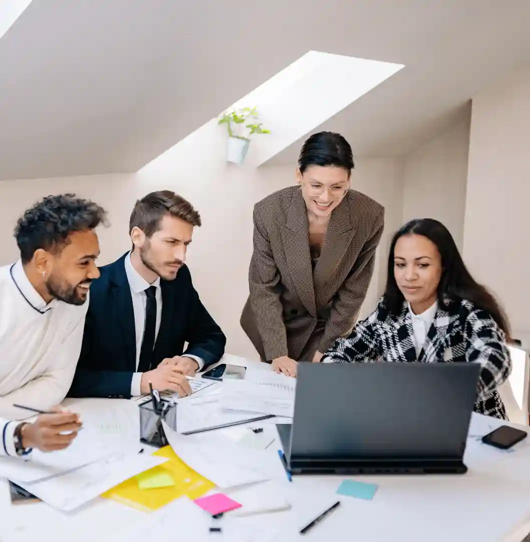 Professionals discussing data on a laptop.