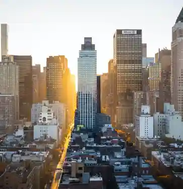 Sun shining through tall city skyscrapers.